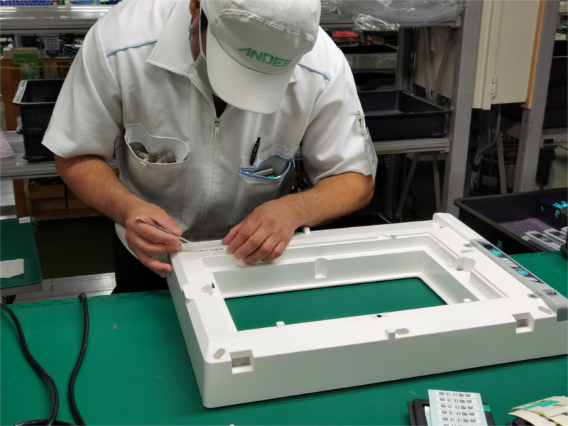 アンデス電気　空気清浄機バイオミクロンBM-H101A　製造工場レポートページ　前枠注意喚起シール貼り付けの様子